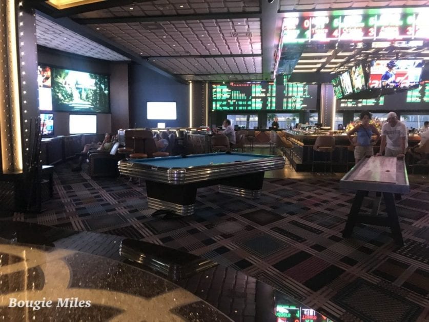 a room with a pool table and a large television screen