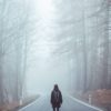 a person walking on a road with trees in the background