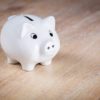 a white piggy bank on a wood surface