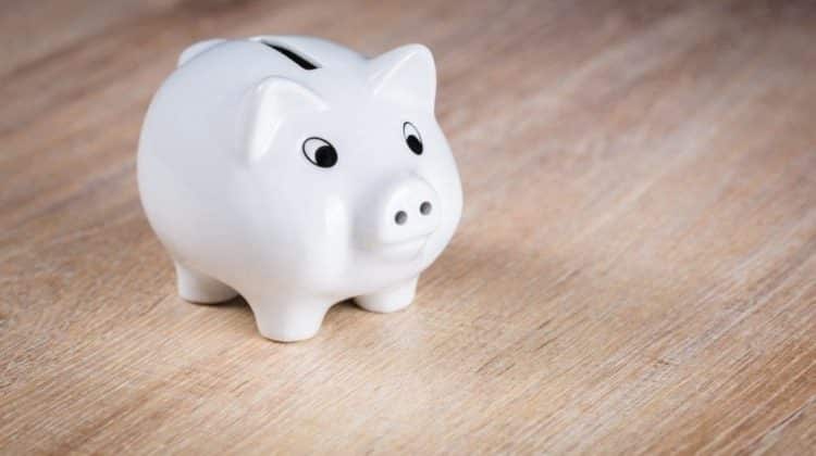 a white piggy bank on a wood surface