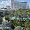 a pool and palm trees in front of a hotel