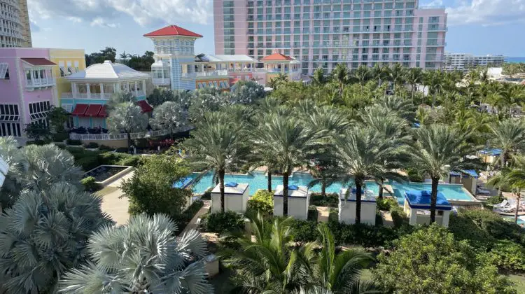 a pool and palm trees in front of a hotel