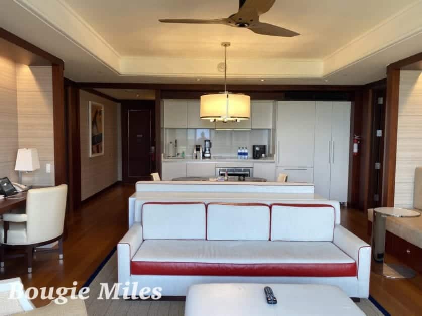 a living room with white furniture and a white ceiling fan