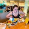 a woman sitting at a table with food on it