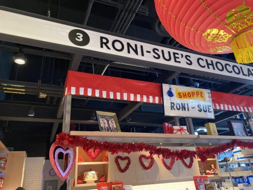 a red and white sign with a red lantern from the ceiling