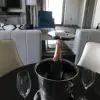 a bottle of champagne in a bucket on a table with two wine glasses