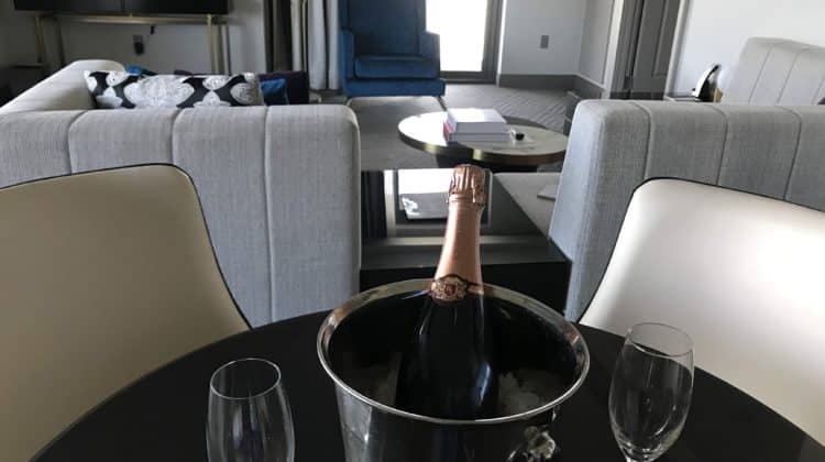 a bottle of champagne in a bucket on a table with two wine glasses