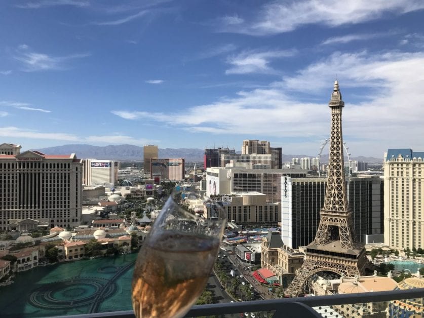 a glass of wine in front of a city