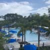 a pool with blue umbrellas and palm trees