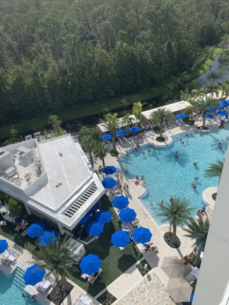 a pool with blue umbrellas and trees