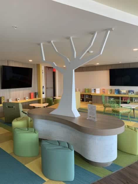 a reception desk with a tree sculpture