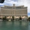 a large building with many windows and a body of water with Bellagio in the background