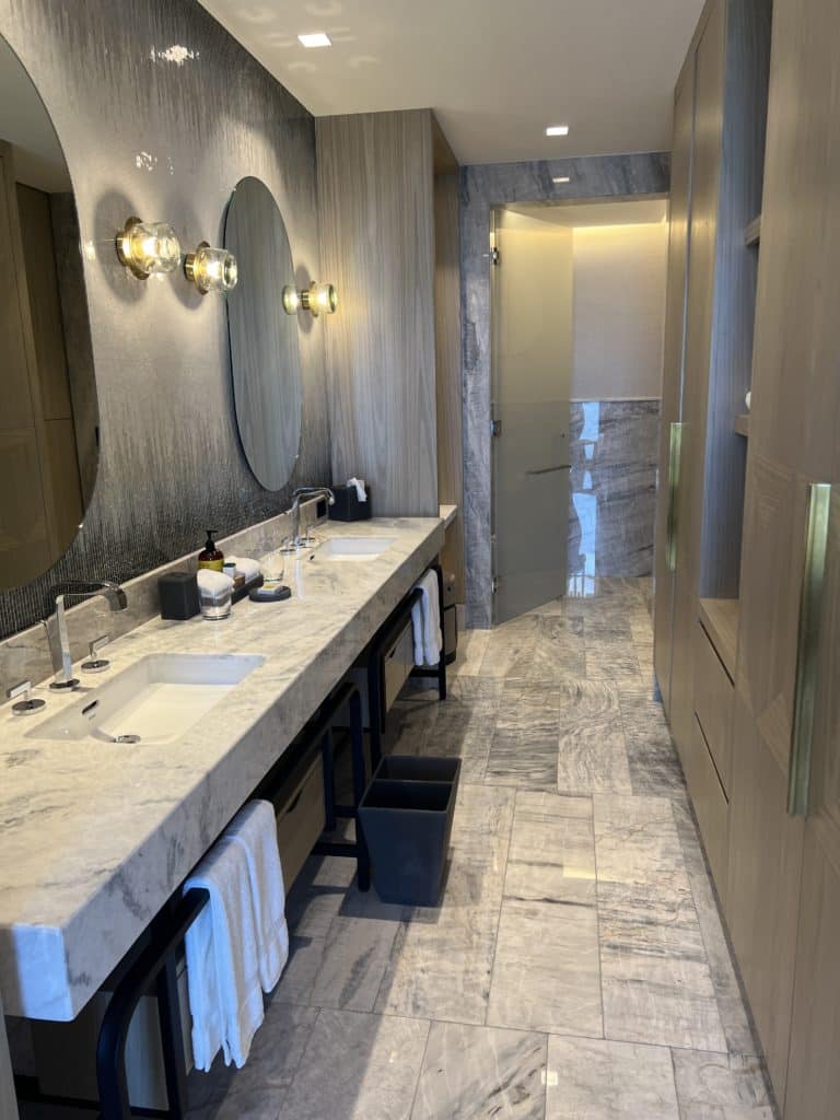 a bathroom with marble countertop sinks and a mirror