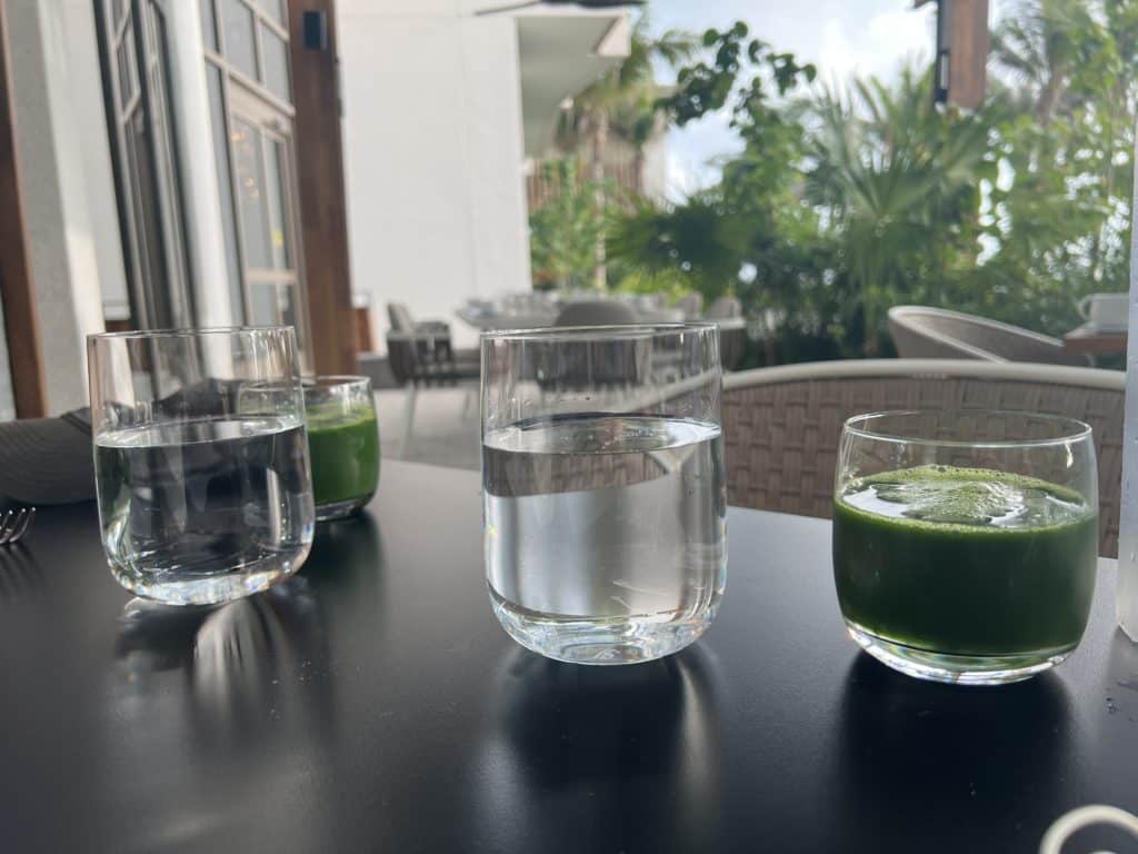 glasses of water and a green drink on a table