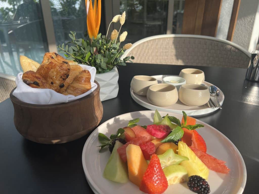 a plate of fruit and croissants on a table