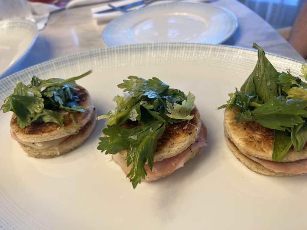 a plate of food with greens on top