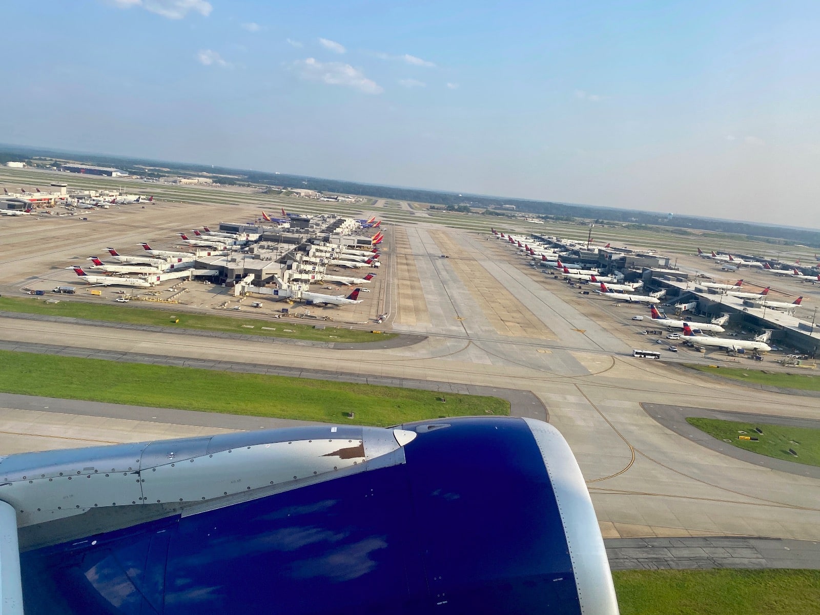 an airplane wing and a runway with many airplanes