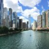 a river with a boat in it and a city with tall buildings