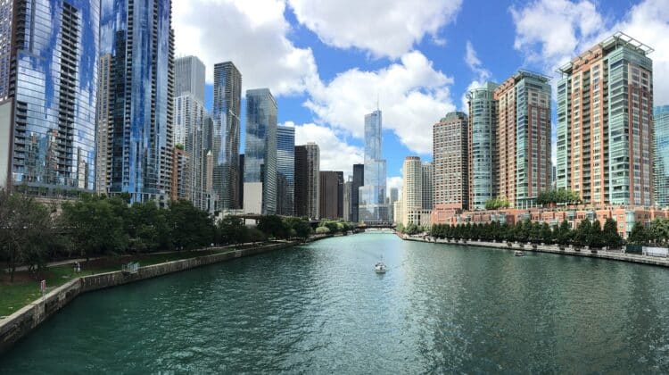 a river with a boat in it and a city with tall buildings