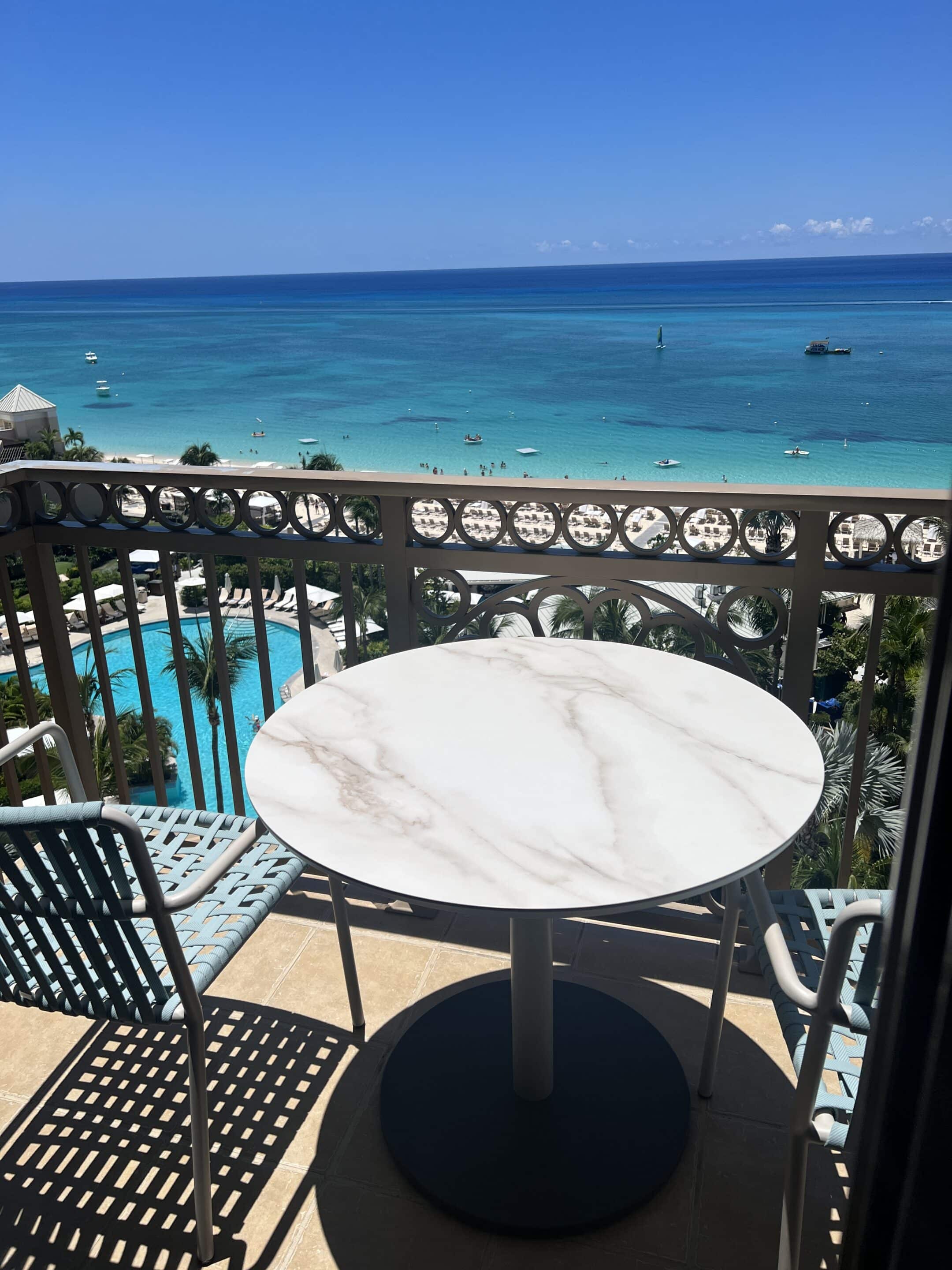 a table and chairs on a balcony overlooking a body of water