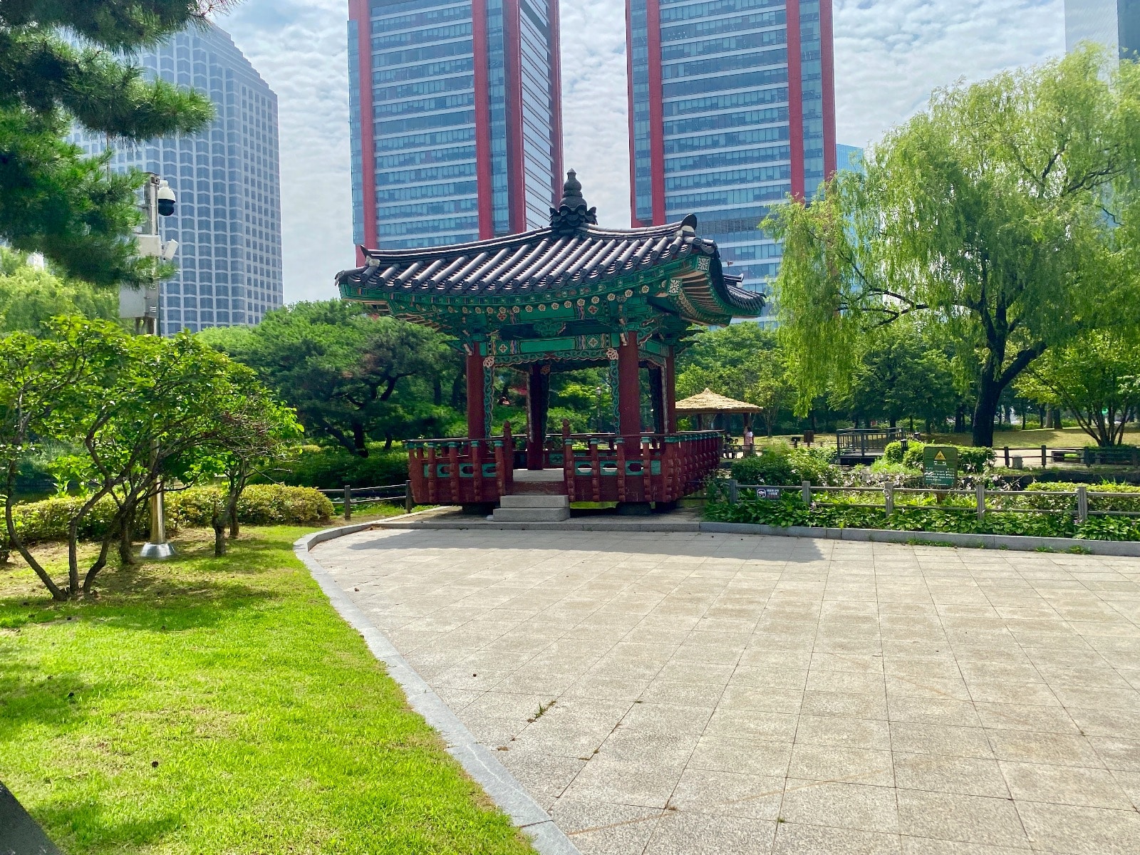 a park with a gazebo and tall buildings
