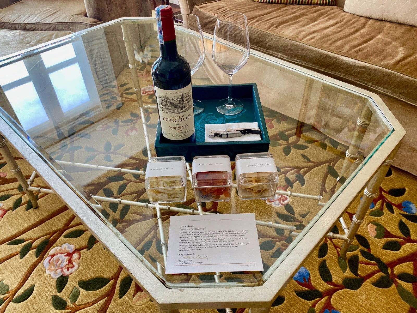 a glass table with a bottle of wine and two glasses