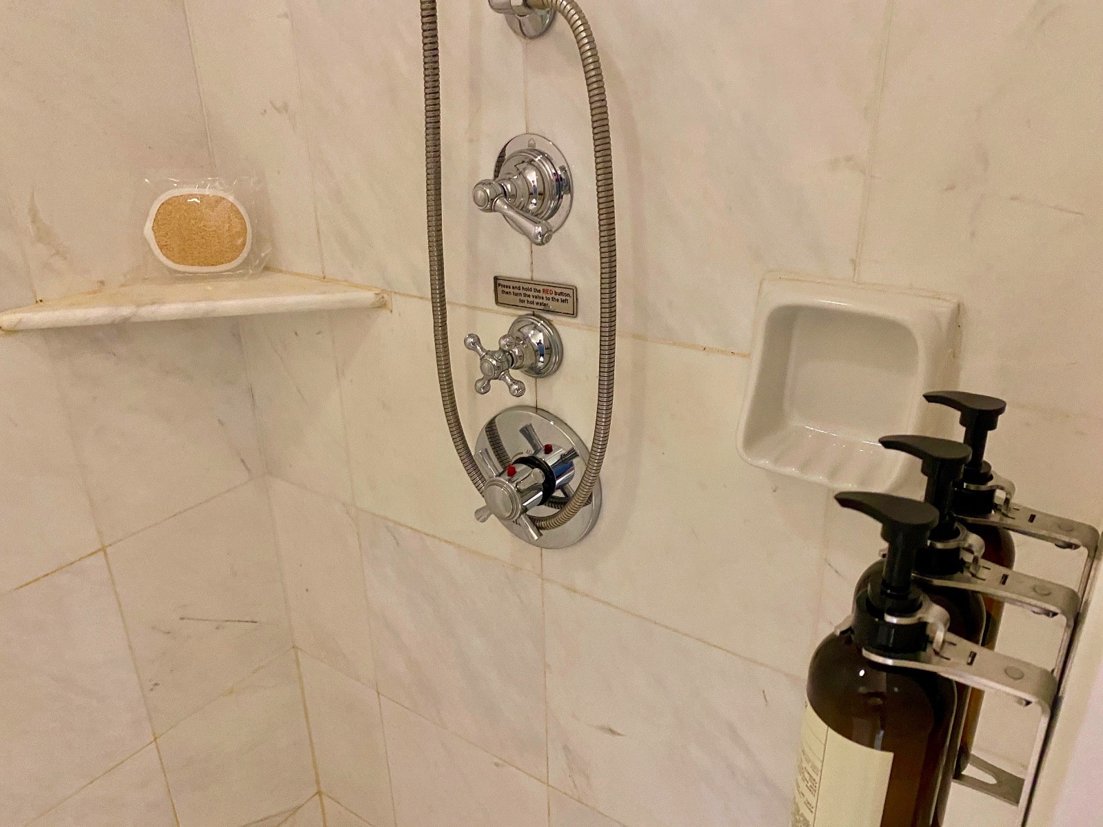 a shower head with a hose and a soap dispenser