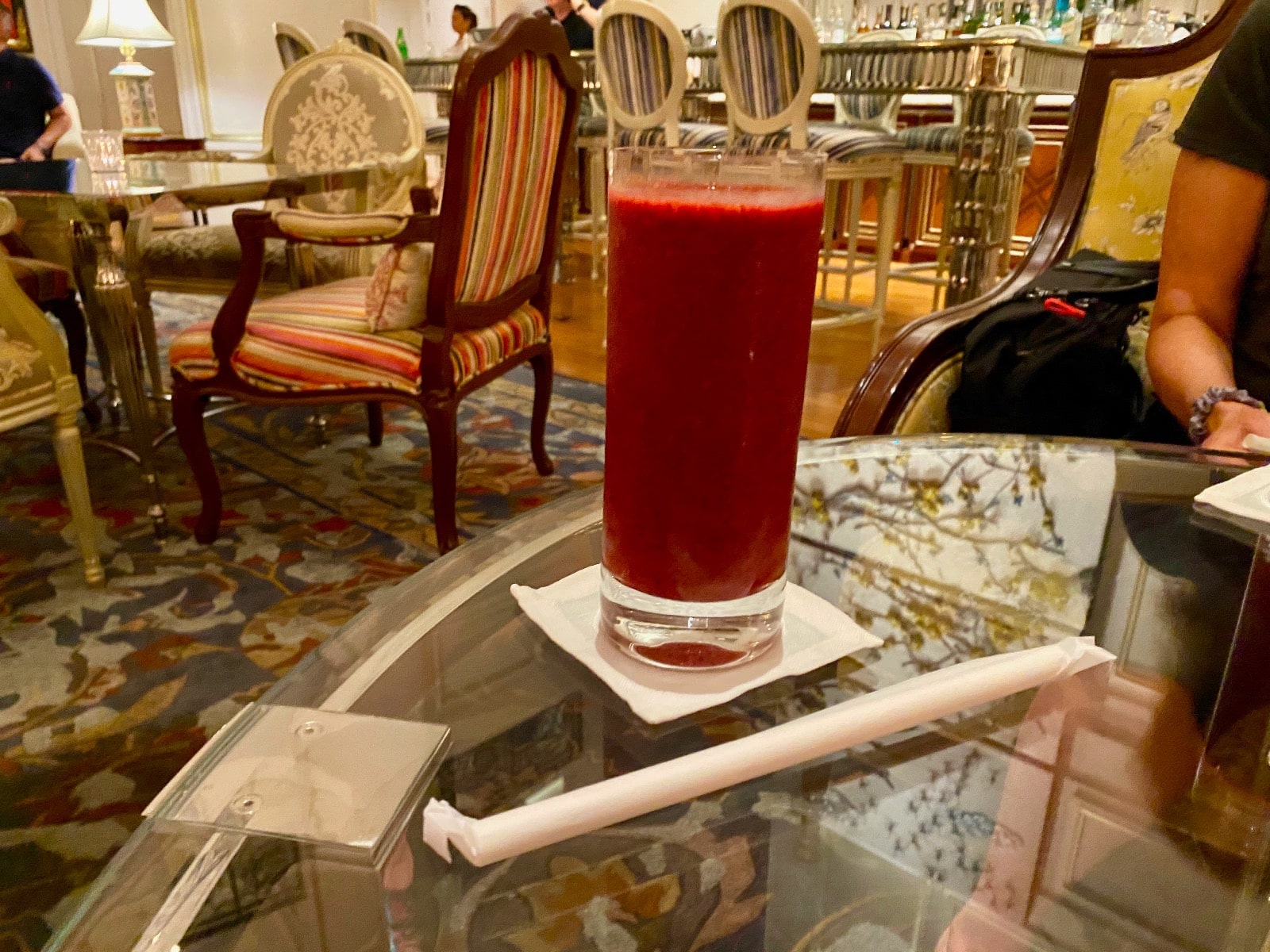 a glass with a red liquid on a table