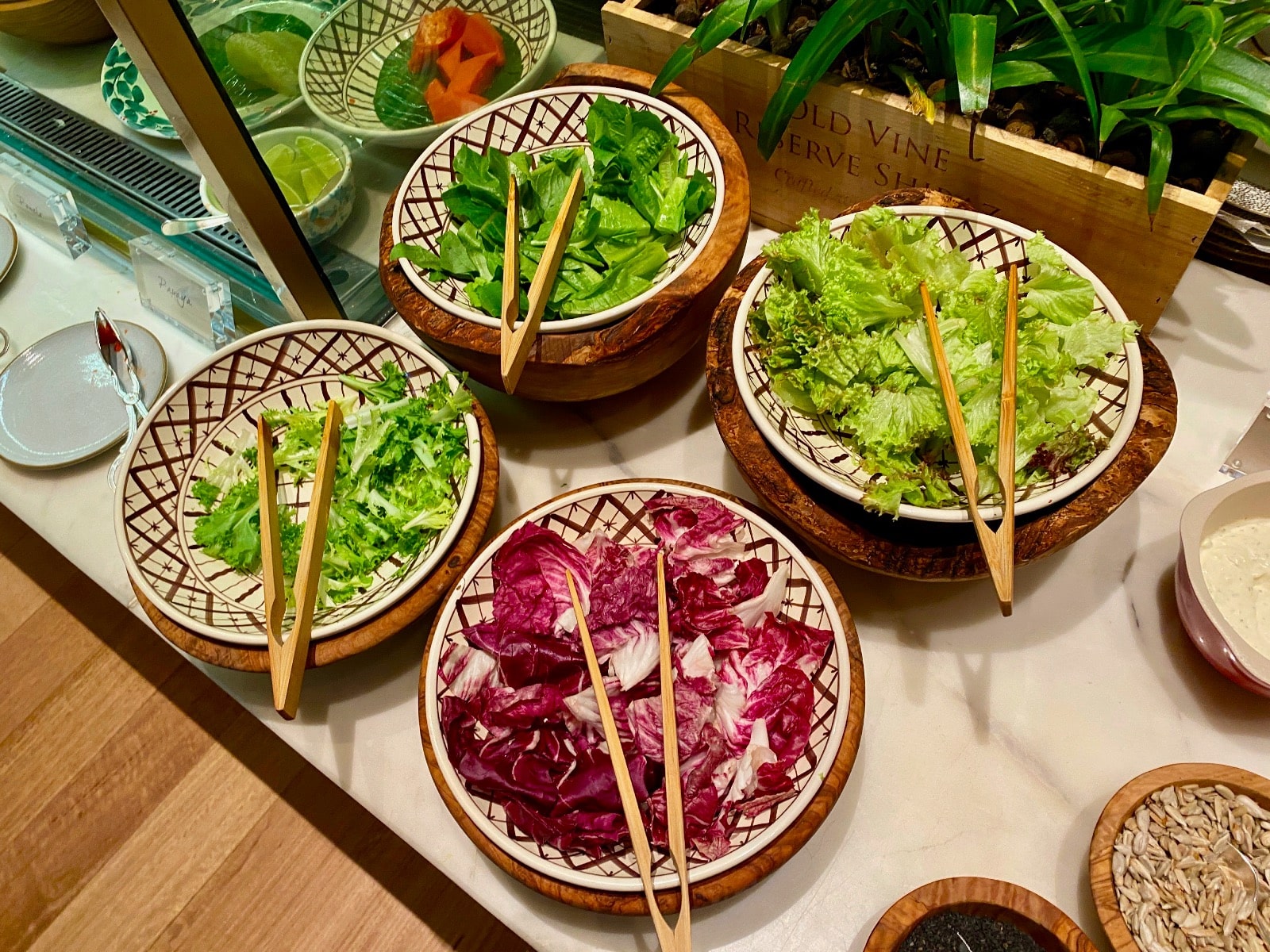 a group of bowls of salad with chopsticks