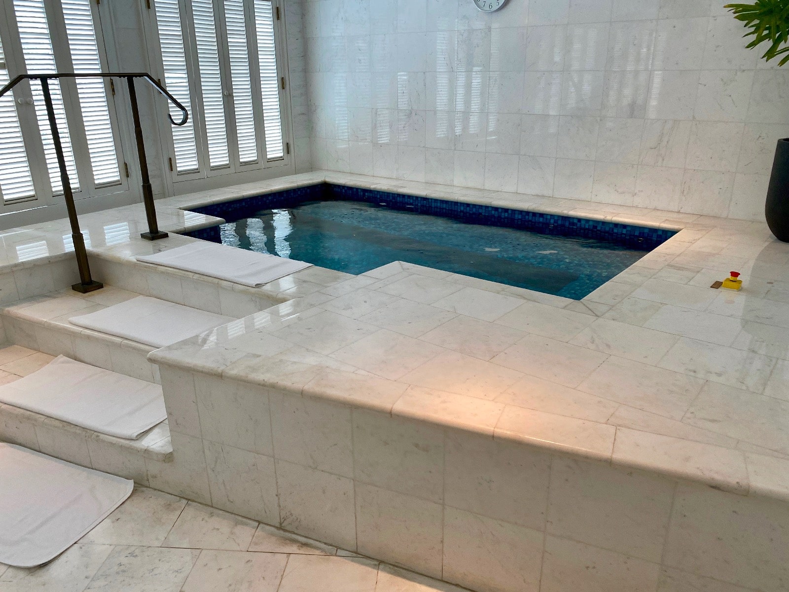 a indoor pool with stairs and a clock