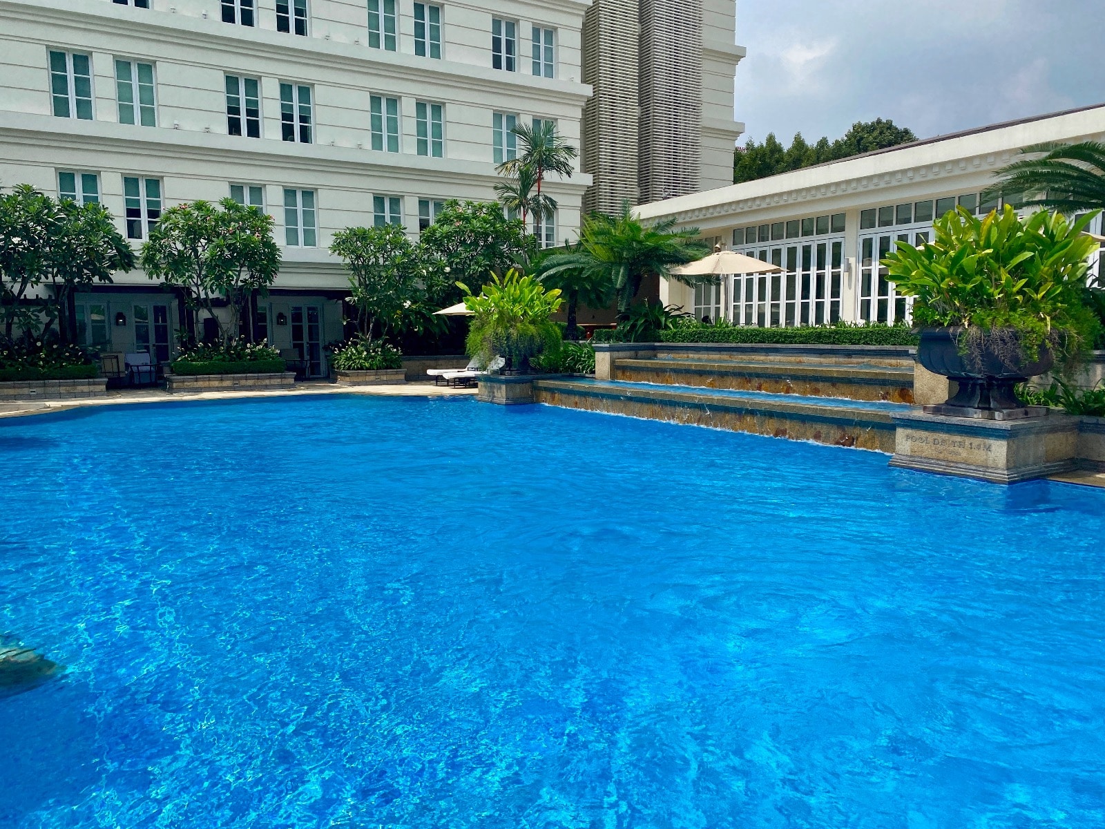 a pool with trees and buildings in the background