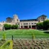a large building with a lawn and bushes