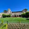 a large building with a lawn and bushes