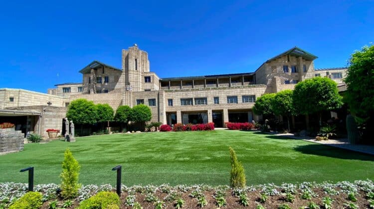 a large building with a lawn and bushes