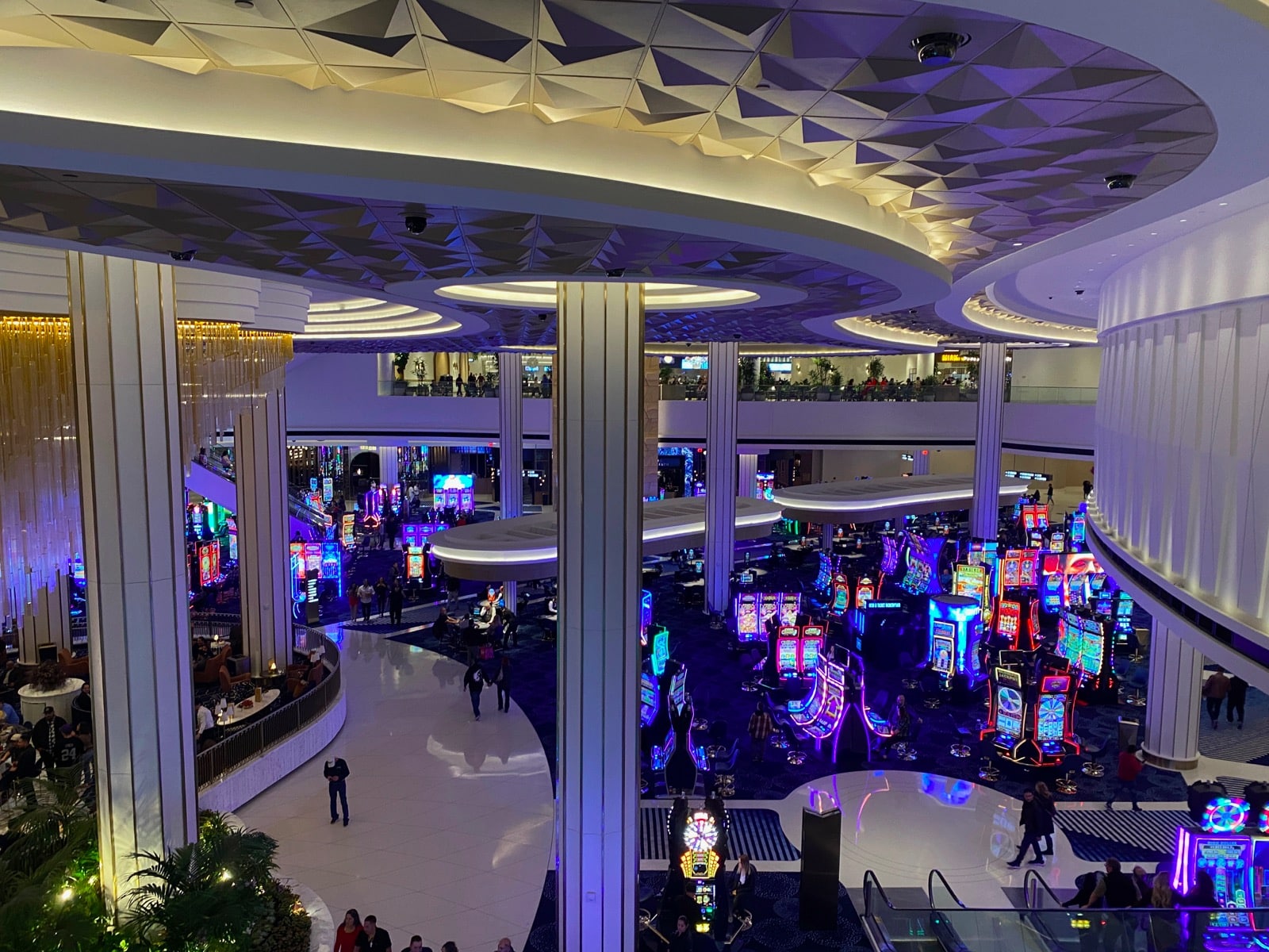 a large casino with lots of people and lots of colorful lights