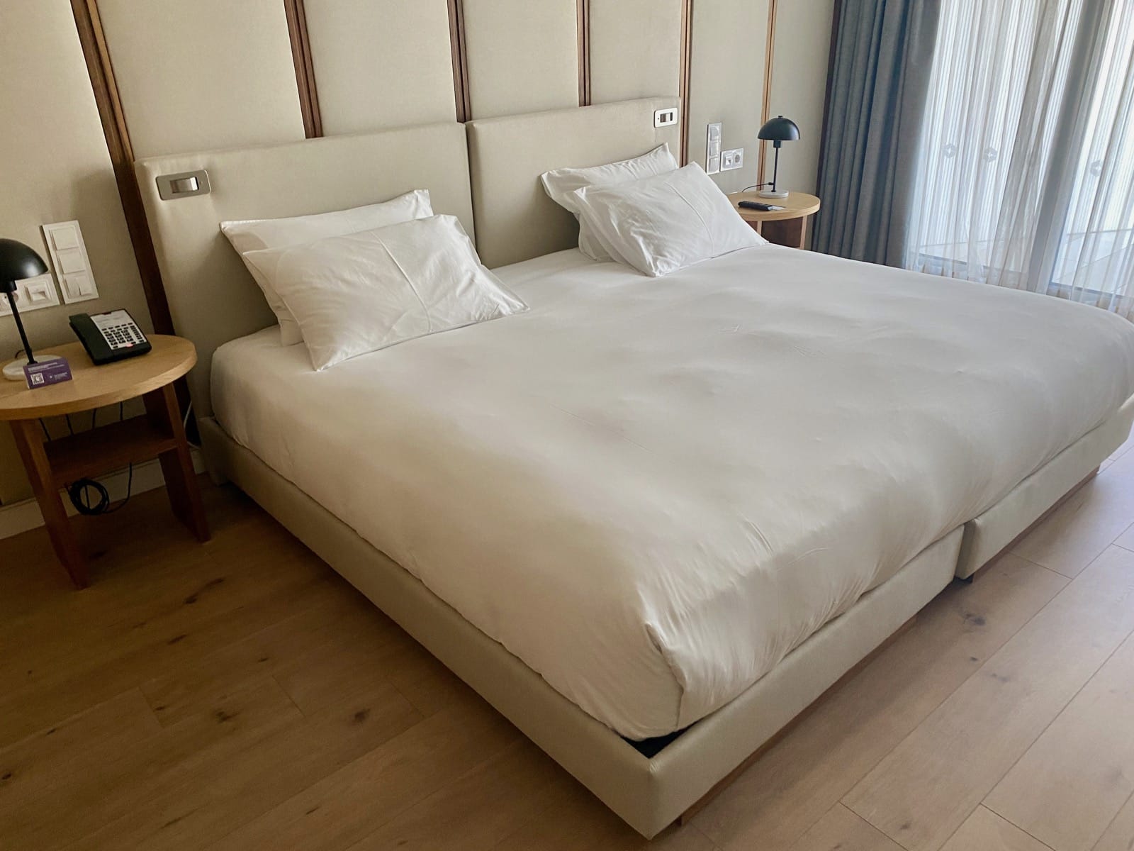 a bed with white sheets and pillows