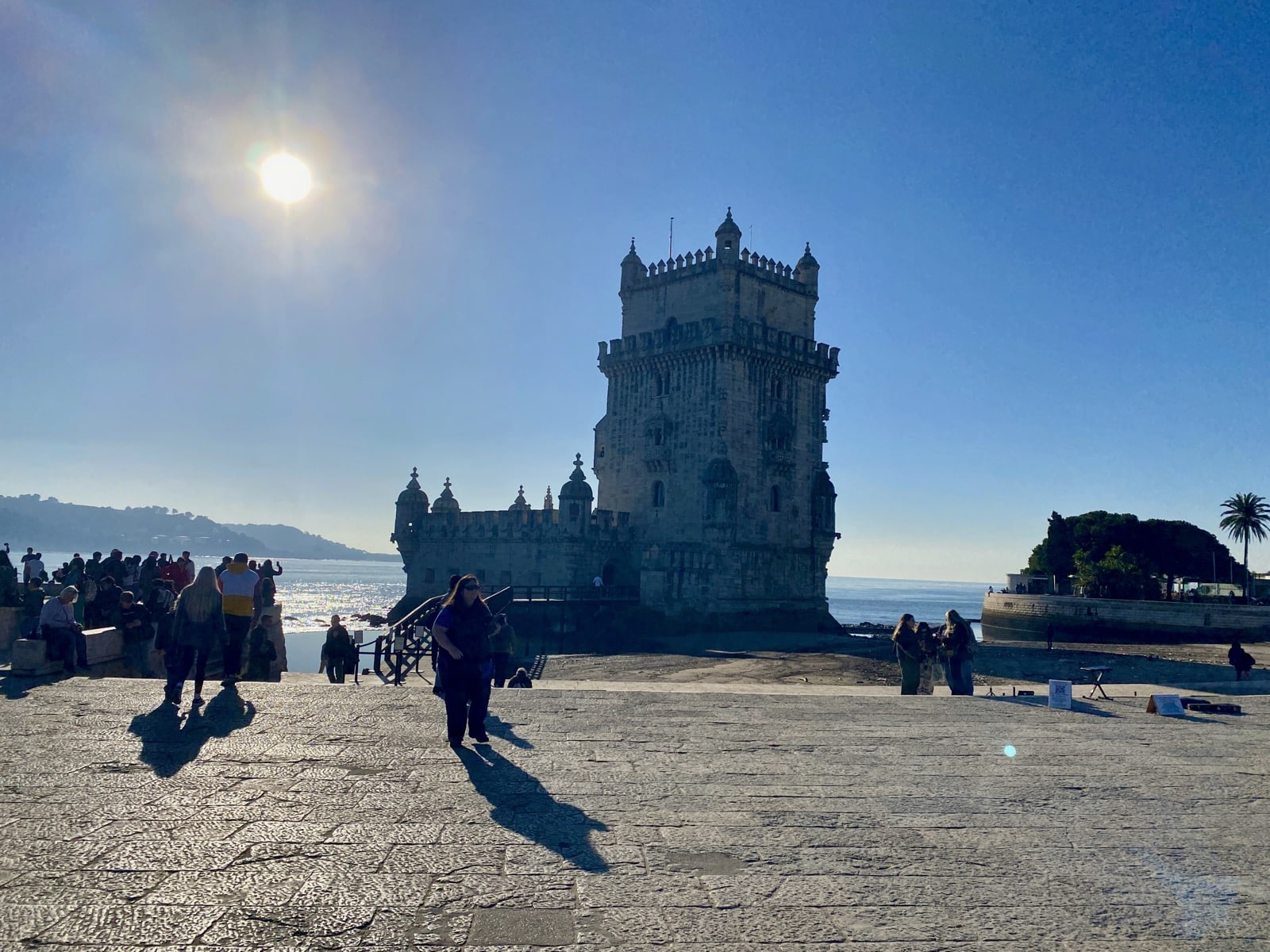 a group of people walking on a stone path next to a castle