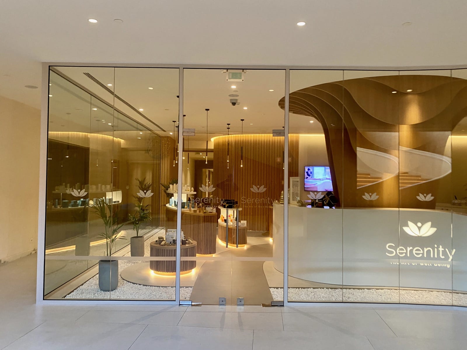 a glass wall with a reception desk and a screen