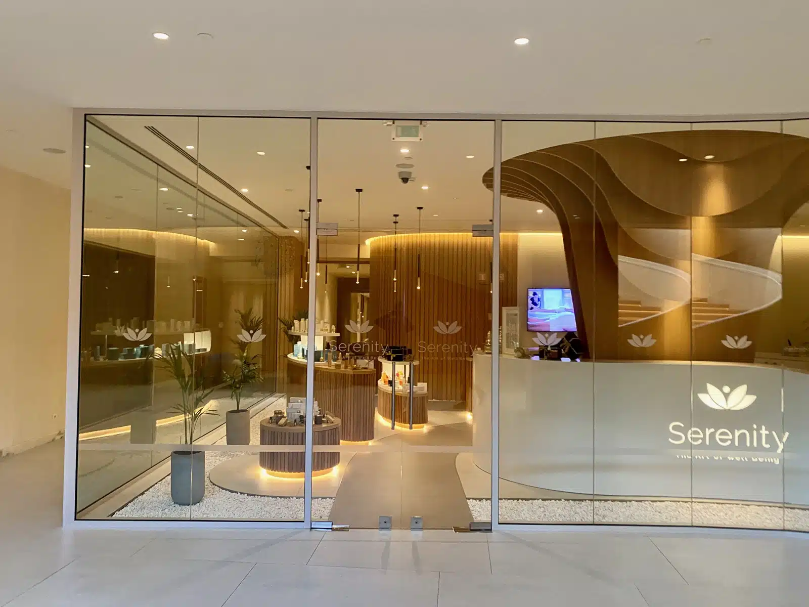a glass wall with a reception desk and a screen