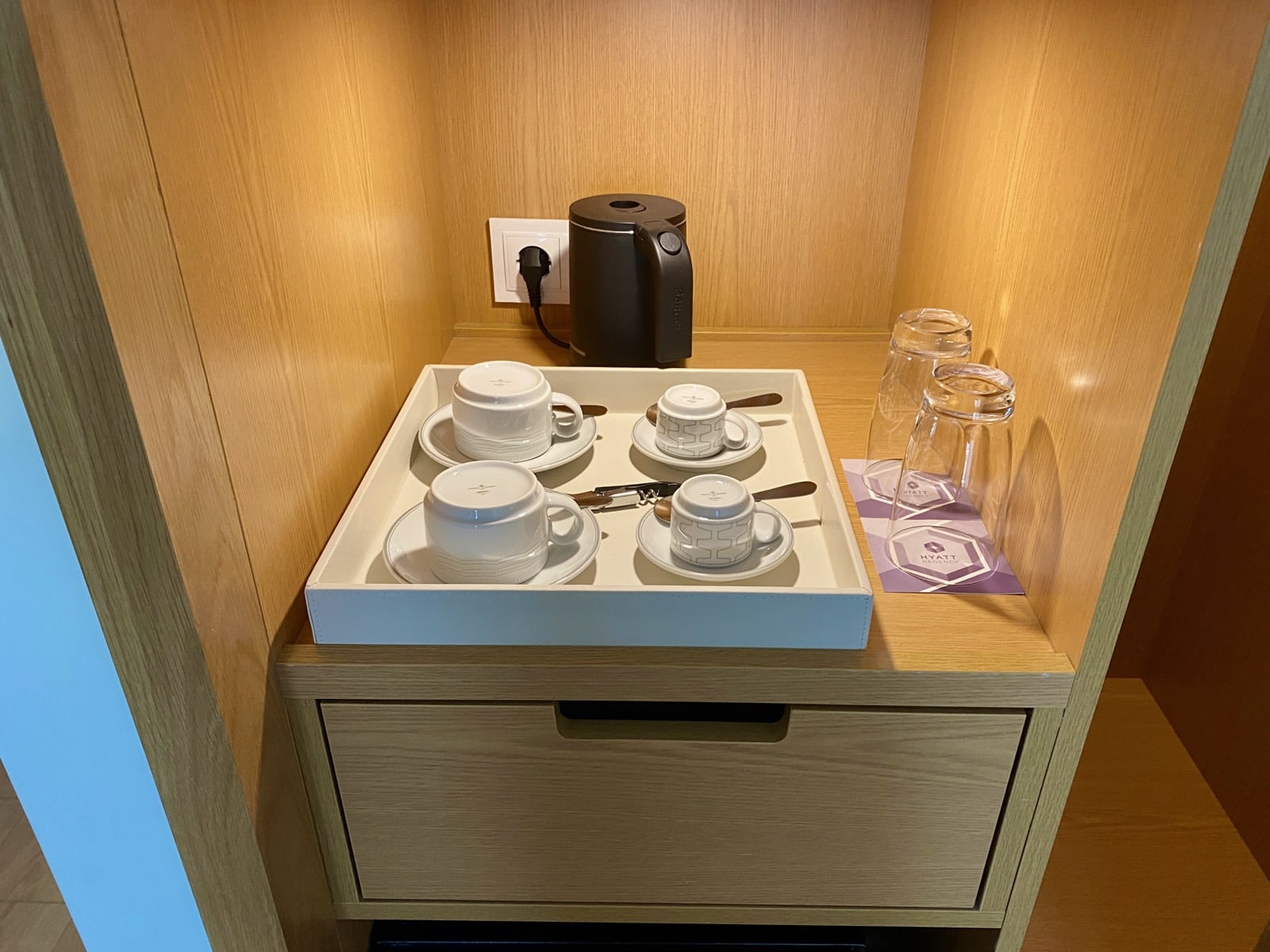 a tray of teacups and saucers on a drawer