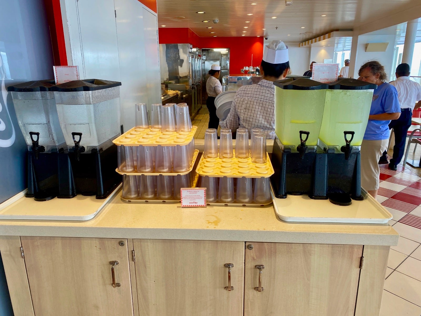 a counter with drinks and cups on it