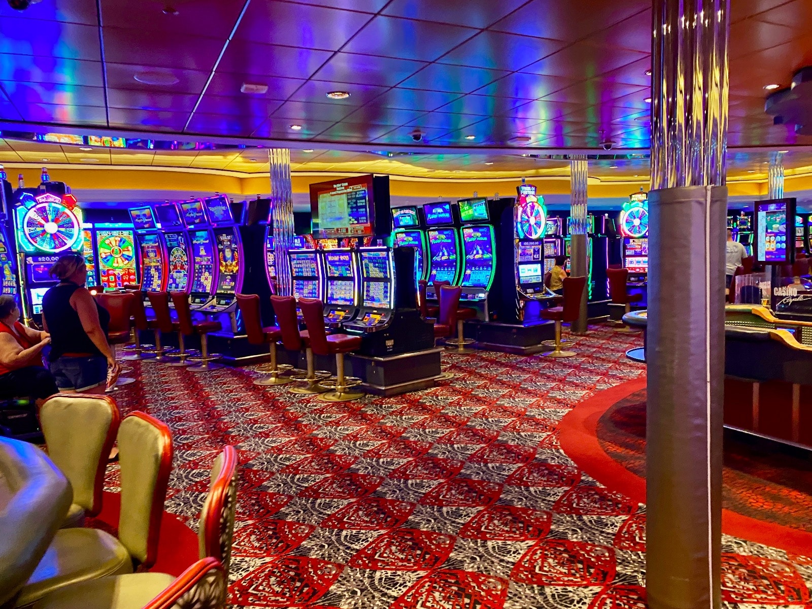 a room with colorful lights and a few slot machines