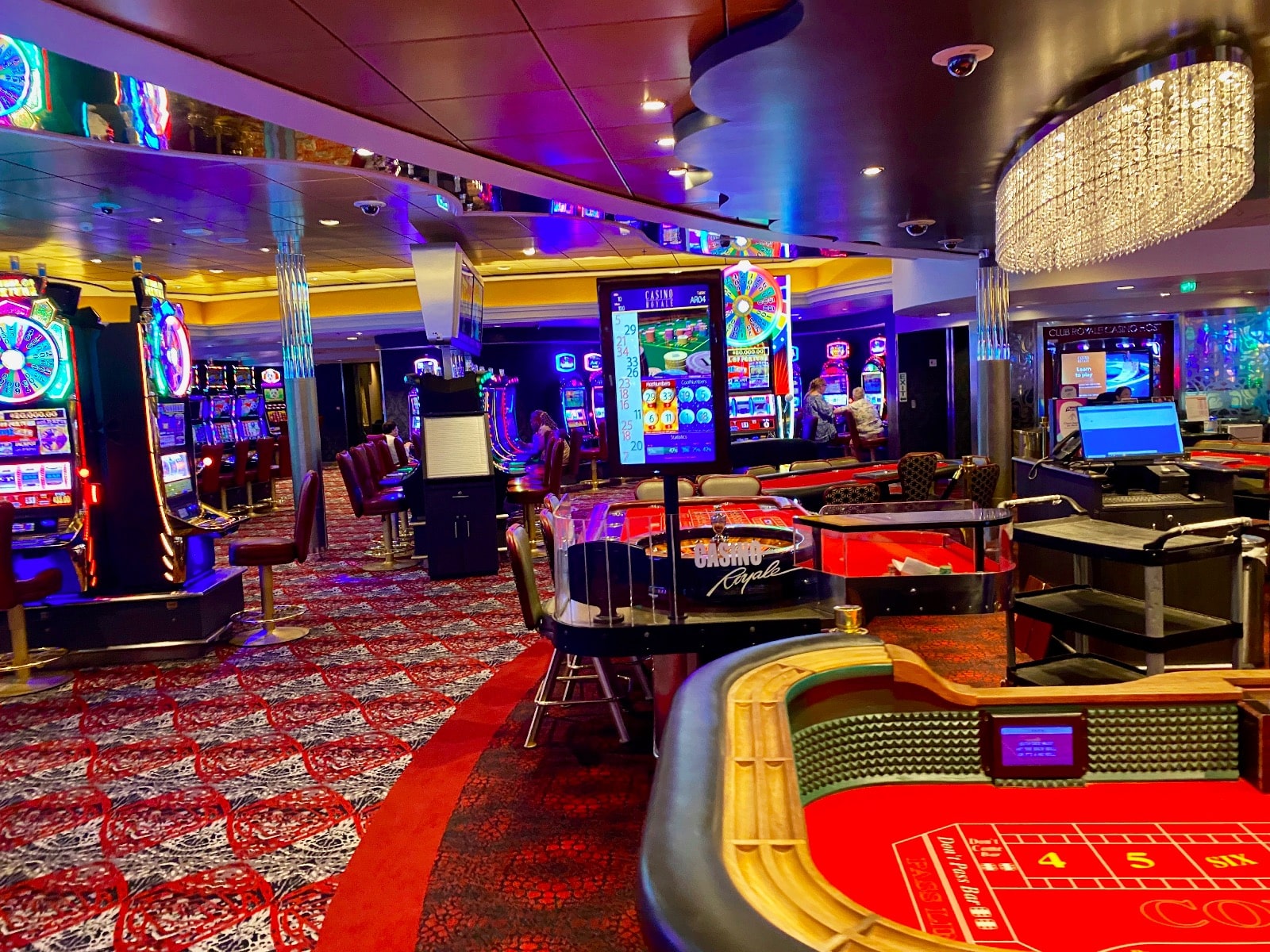 a casino with a red table and gaming machines