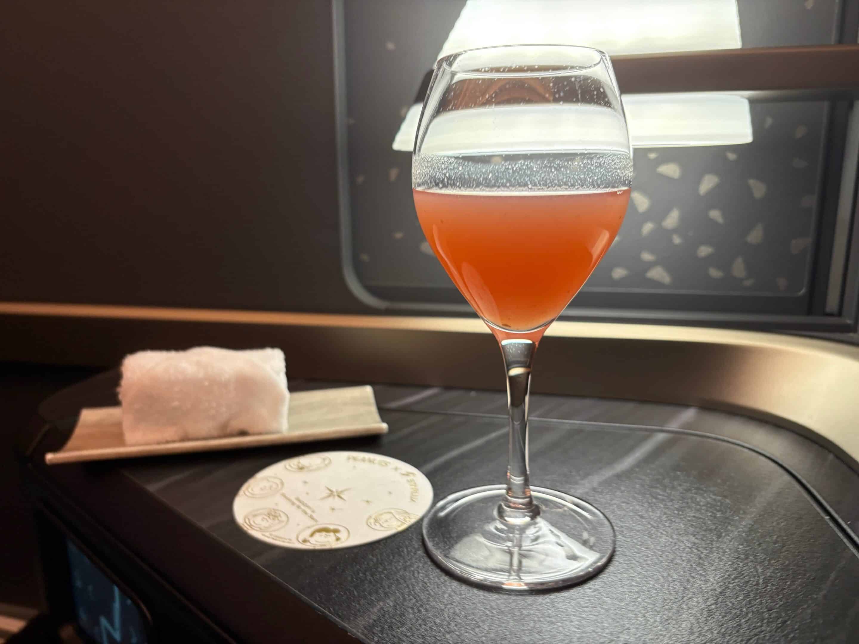 a glass of pink liquid on a table