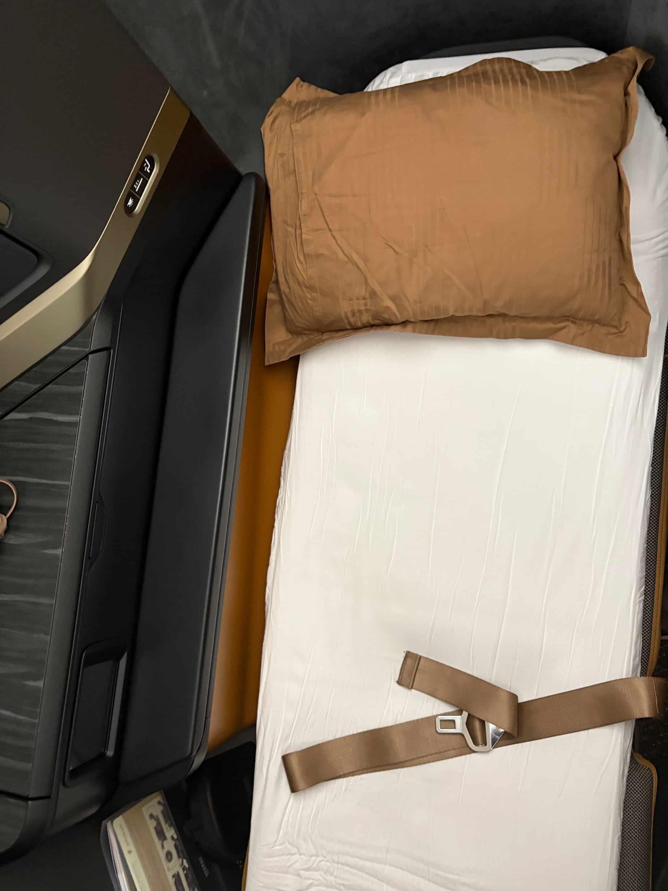 a bed with a pillow and a seat belt