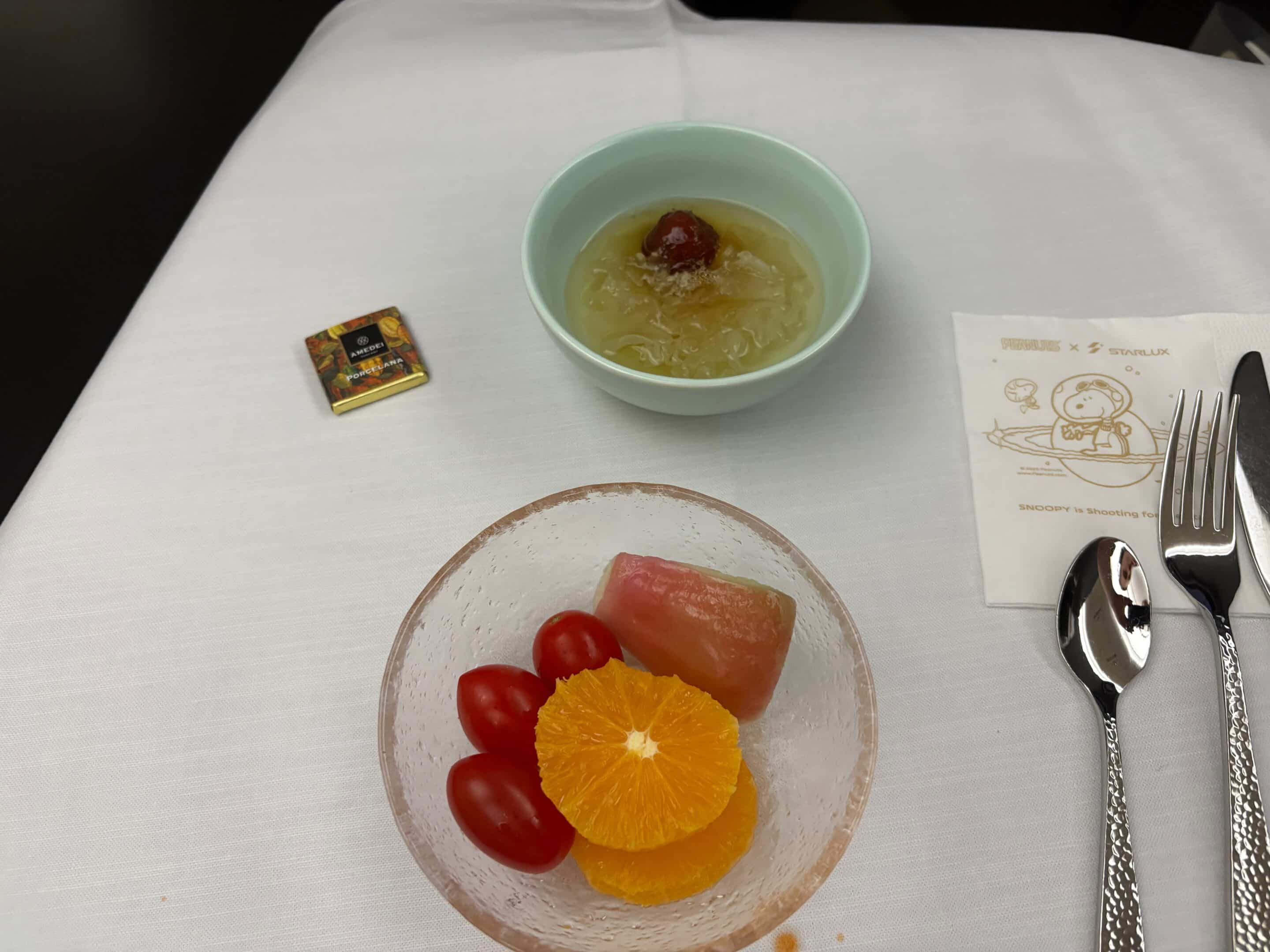 a bowl of fruit and a bowl of jelly on a table