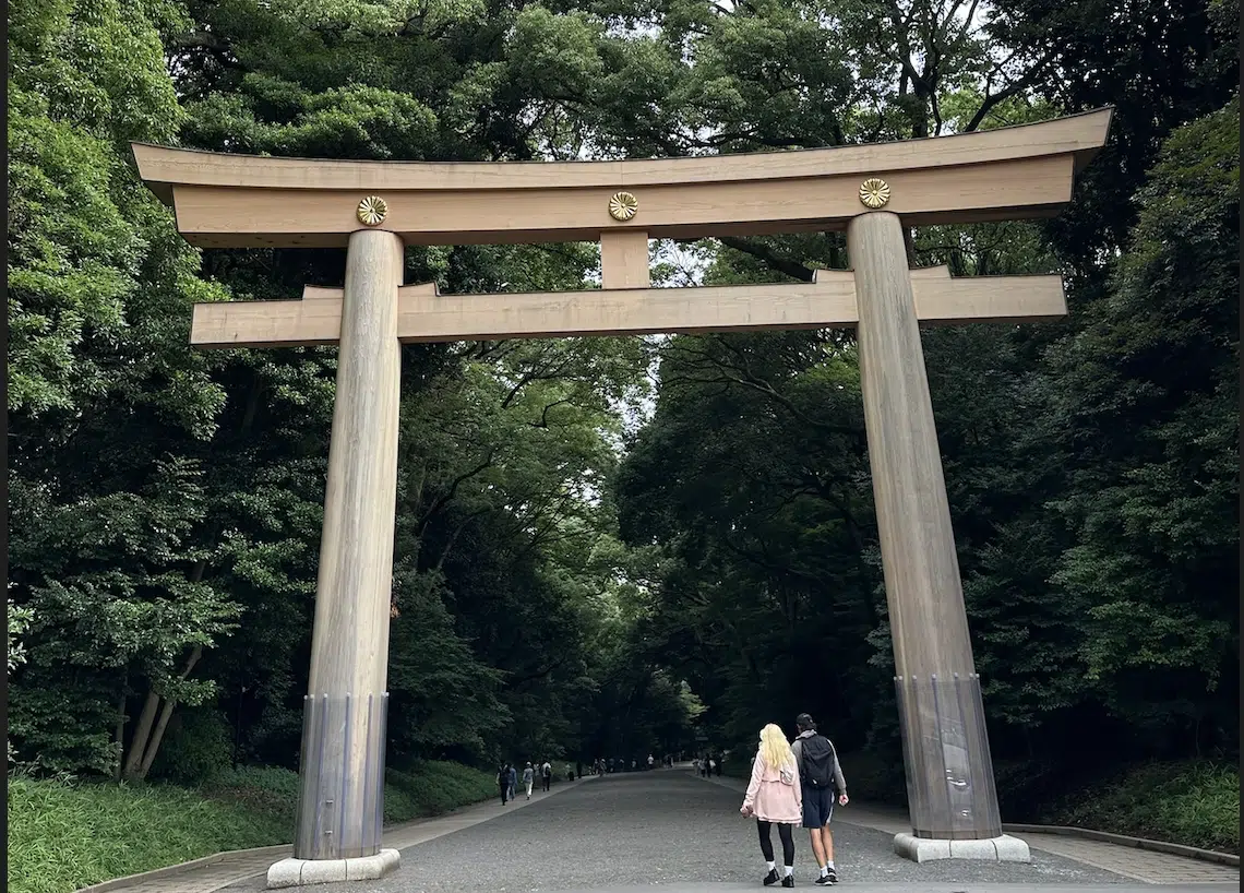 a large wooden arch over a road with people walking