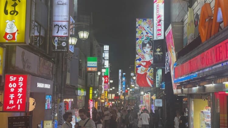 a crowd of people walking down a street with signs
