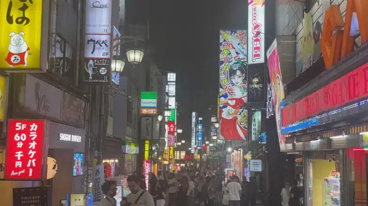 a crowd of people walking down a street with signs