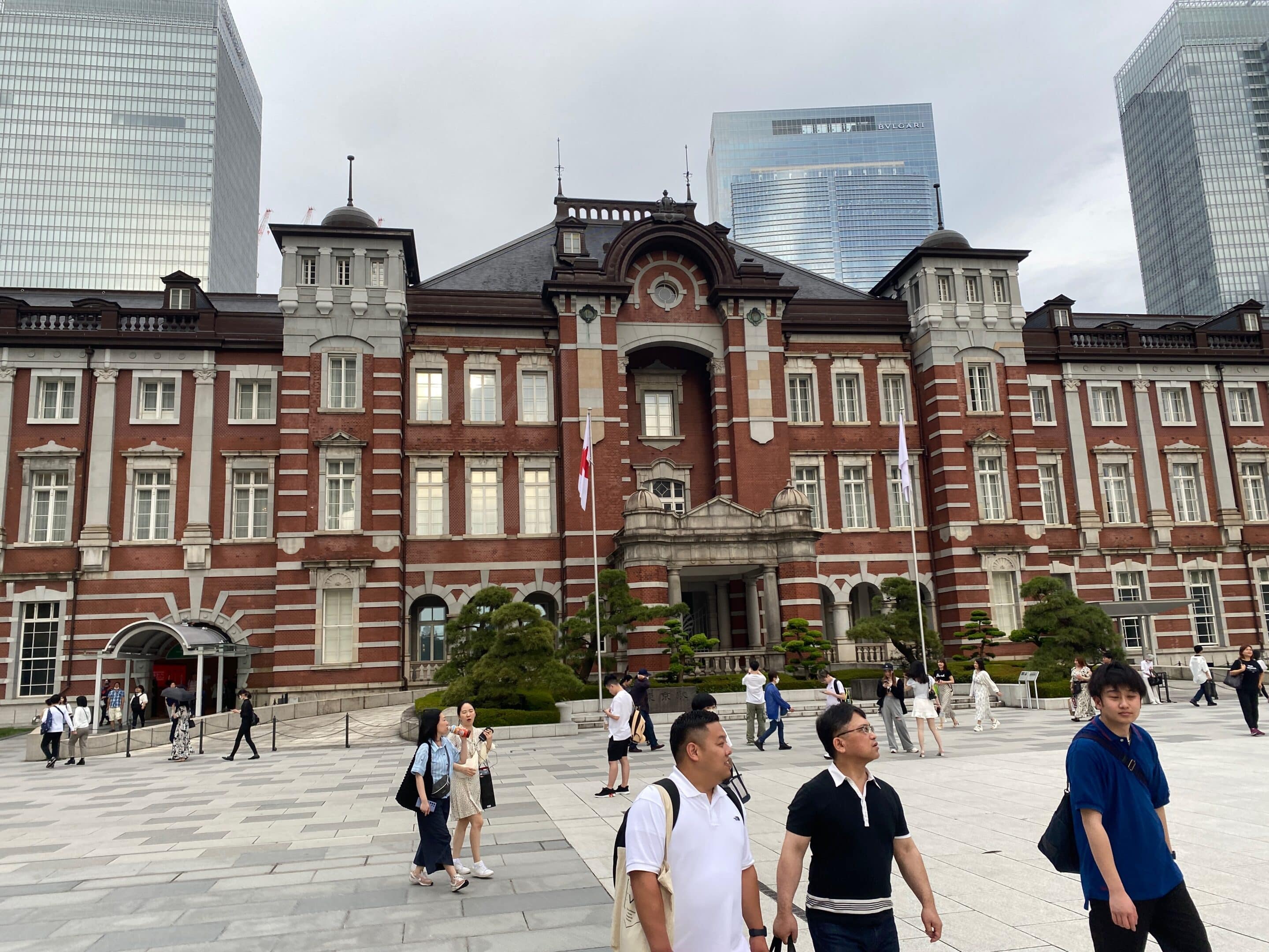 a group of people walking in front of a large building